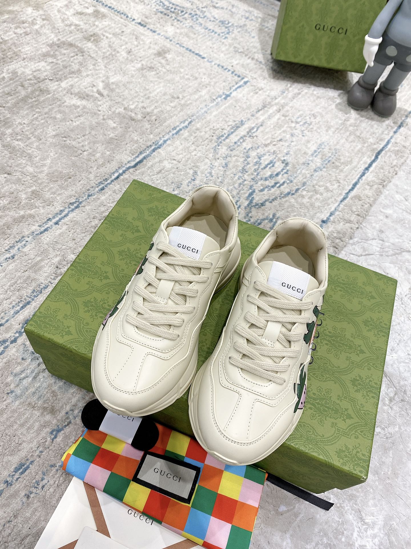 Gucci unisex sneakers, cream lace-up with large strawberry print on sides; matching uppers.