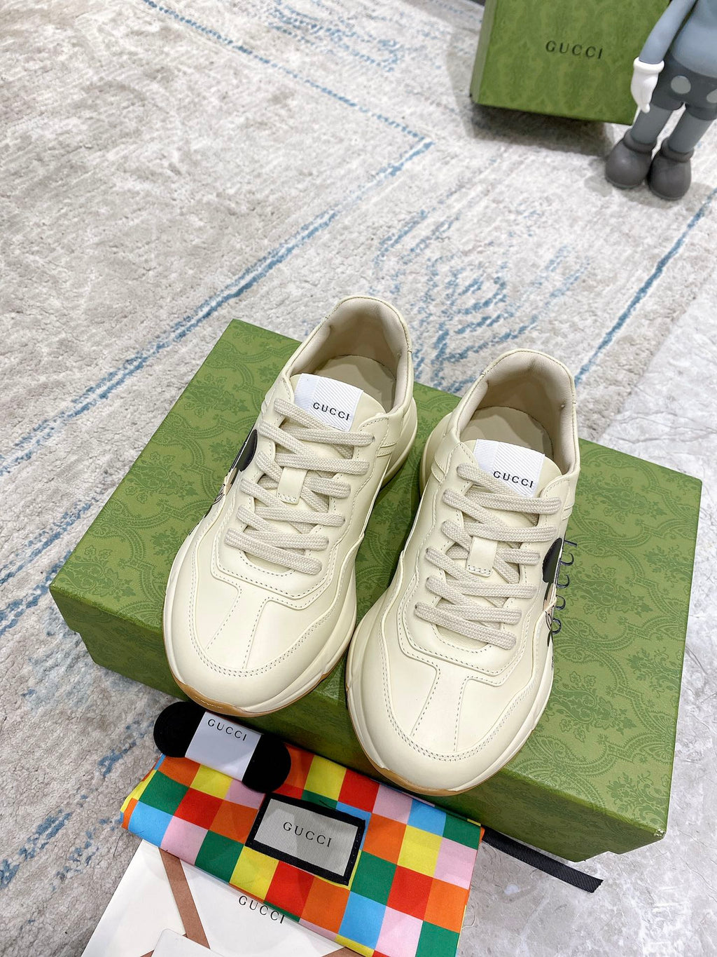 Gucci unisex cream lace-up sneakers on box, with visible laces and logo patch