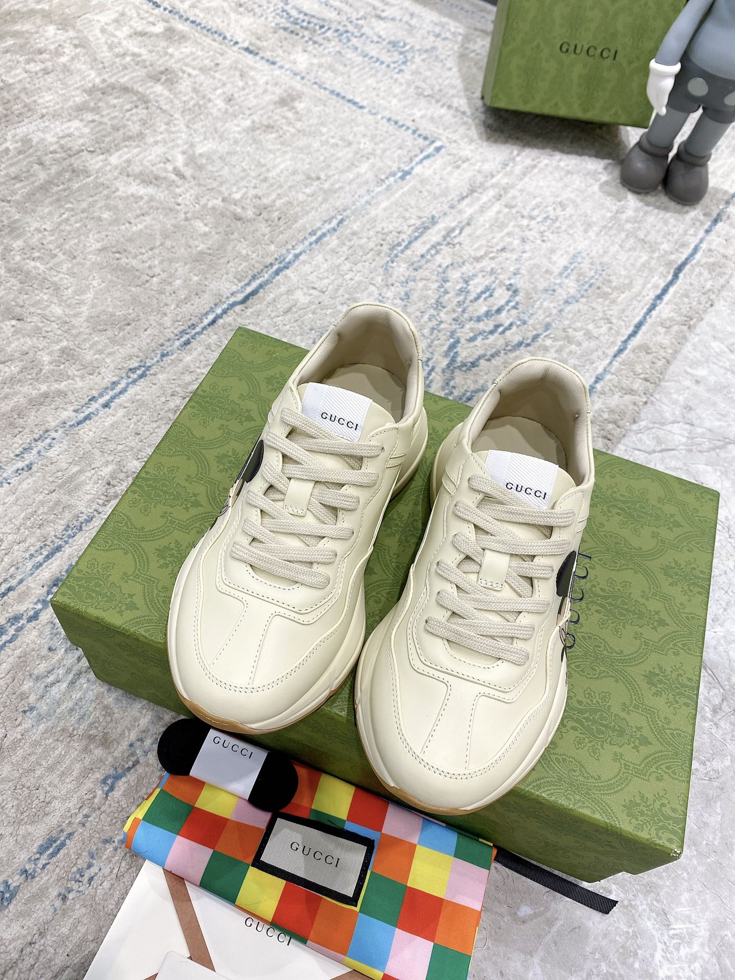 Gucci unisex cream lace-up sneakers on box, with visible laces and logo patch