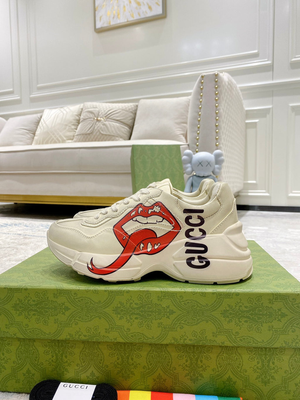 Light-cream Gucci unisex sneakers on green box, side view with red lip graphic