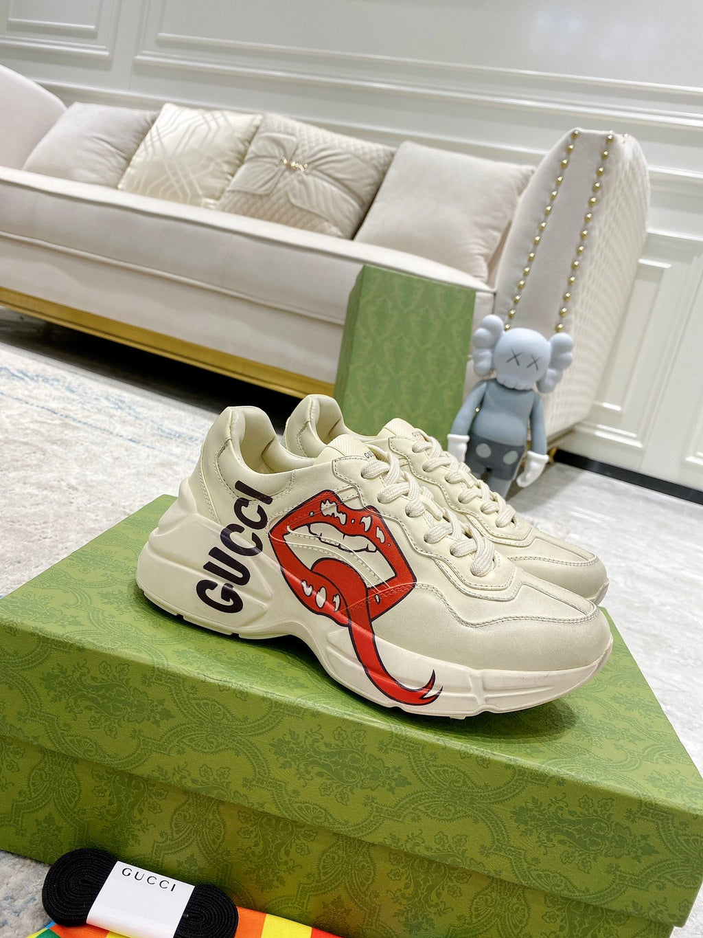 Light-cream Gucci unisex sneakers with red lip graphic and black Gucci logo detail