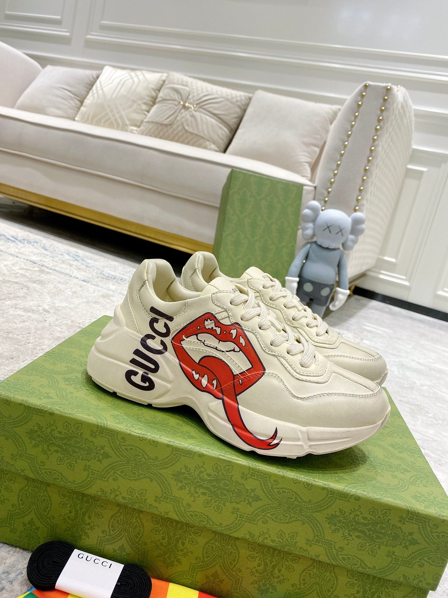 Light-cream Gucci unisex sneakers with red lip graphic and black Gucci logo detail