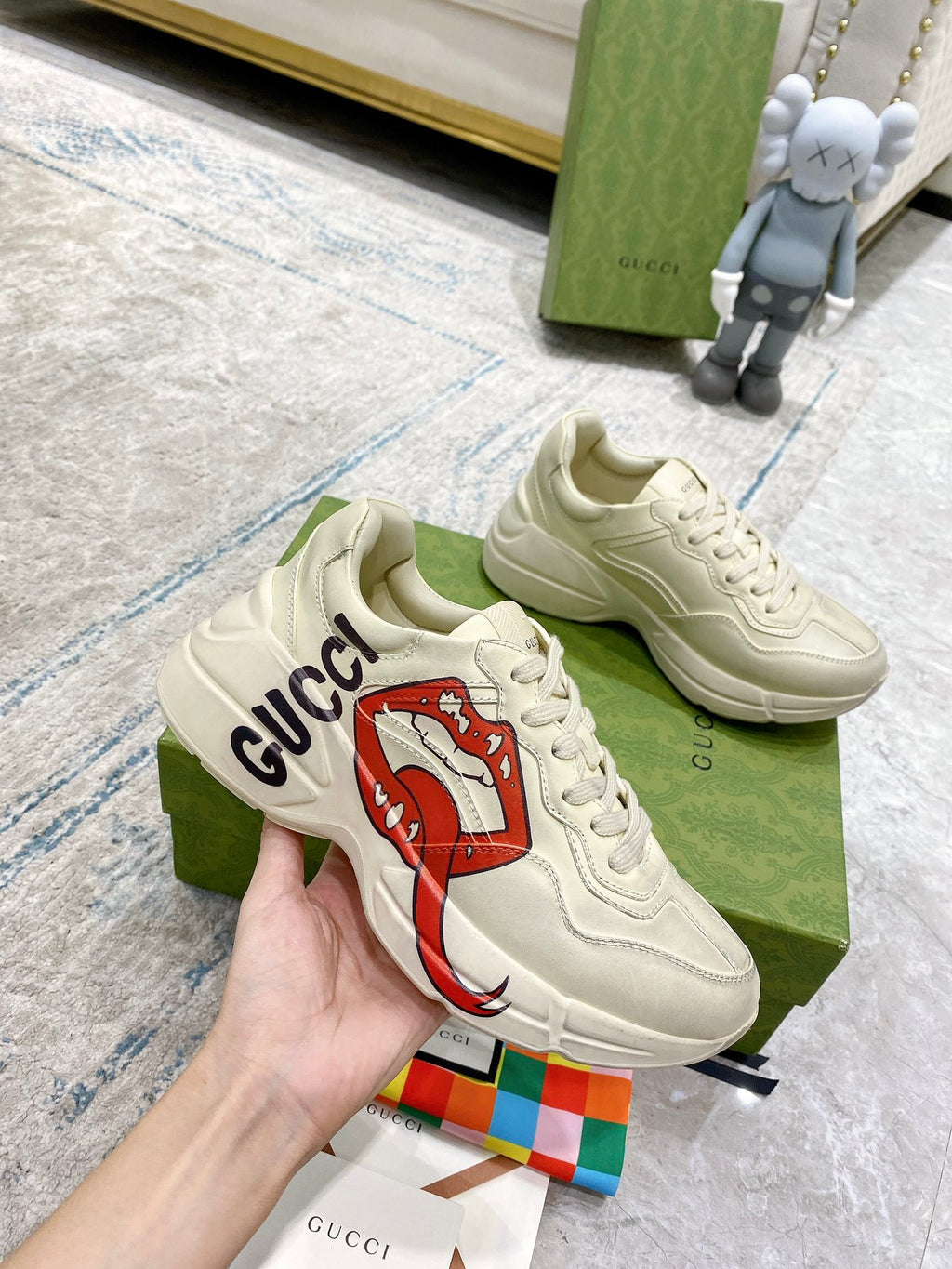Light-cream Gucci unisex sneakers, lace-up front view with red lip graphic
