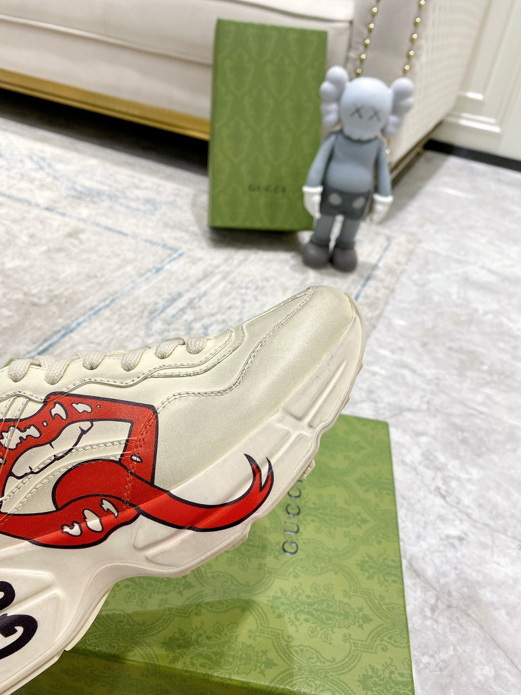 Light-cream Gucci unisex sneaker close-up of red lip graphic and side stripe stitching