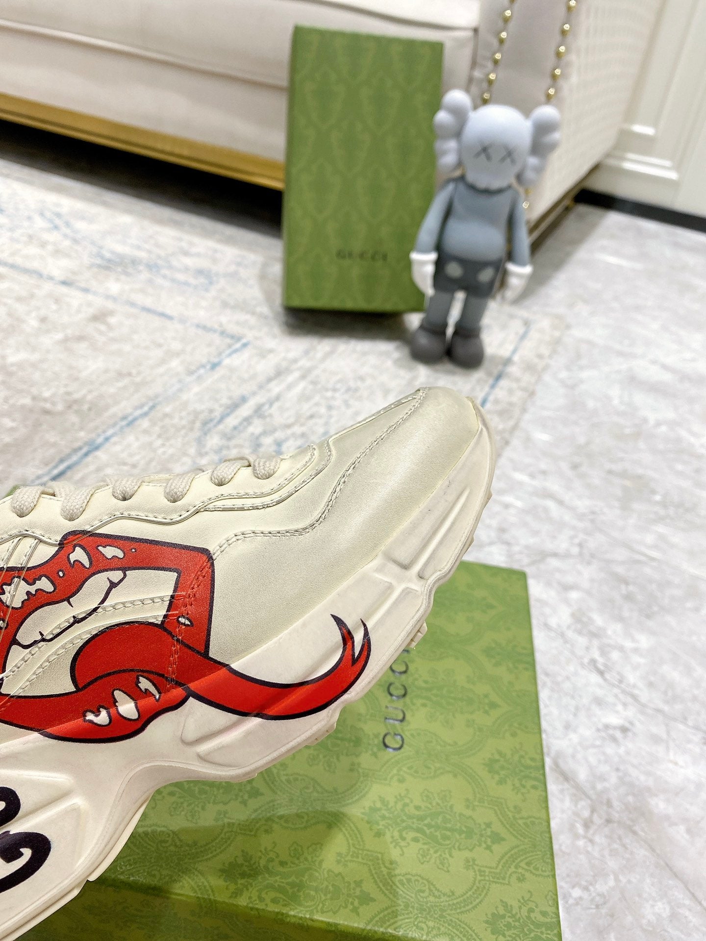 Light-cream Gucci unisex sneaker close-up of red lip graphic and side stripe stitching