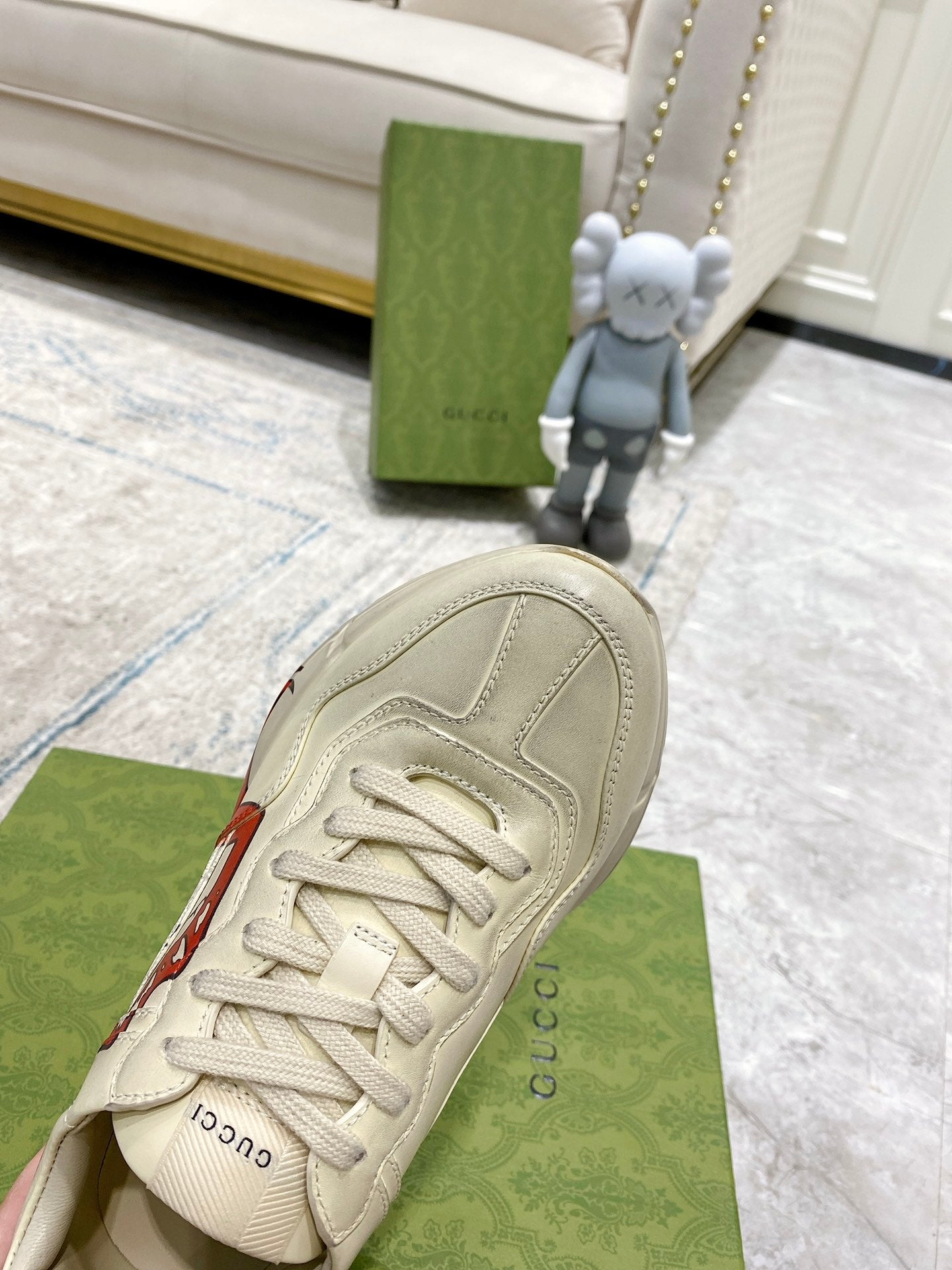 Light-cream Gucci unisex sneaker with stitched upper and red lip graphic on side