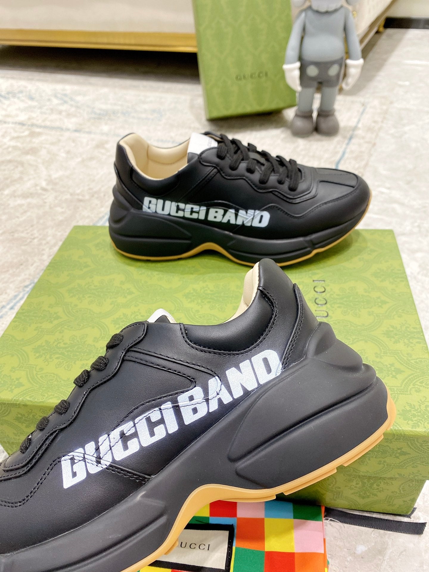 Gucci unisex sneakers, black upper close-up with GucciBand logo and gum trim