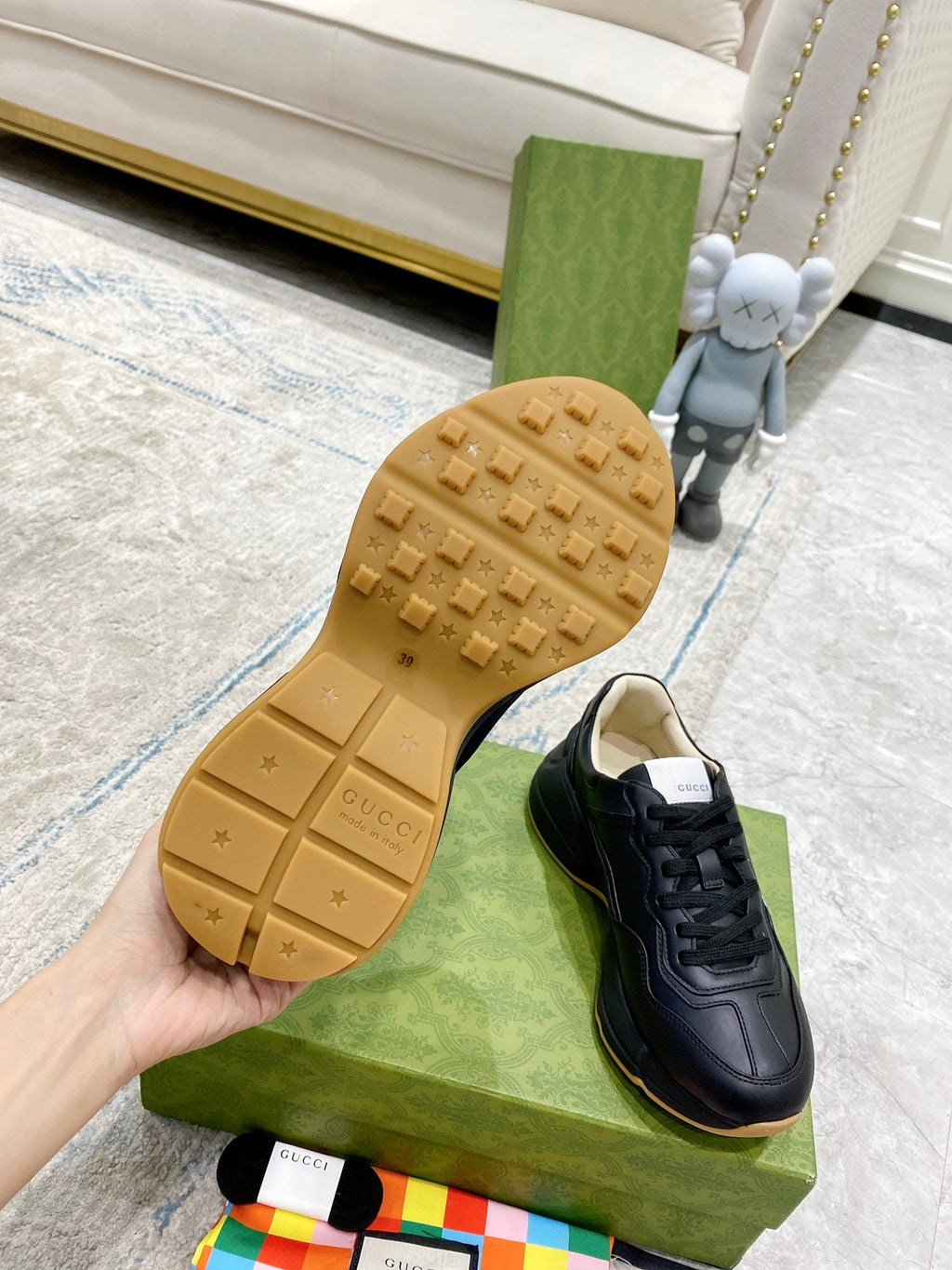 Gucci unisex sneaker outsole view, textured rubber sole on green box