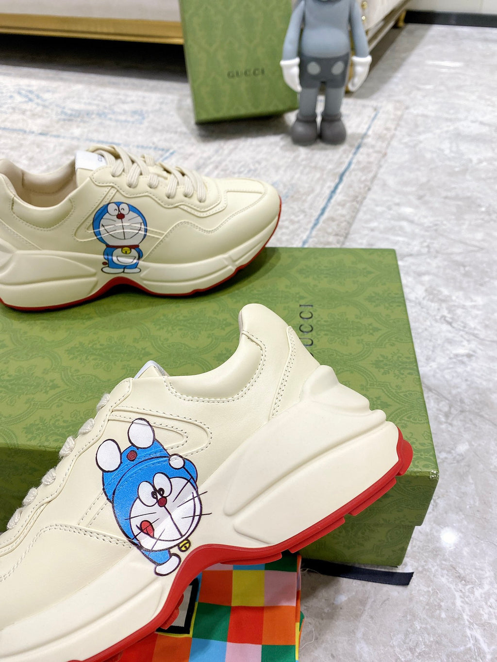 Gucci unisex sneakers, close-up showing Doraemon patch on white leather upper