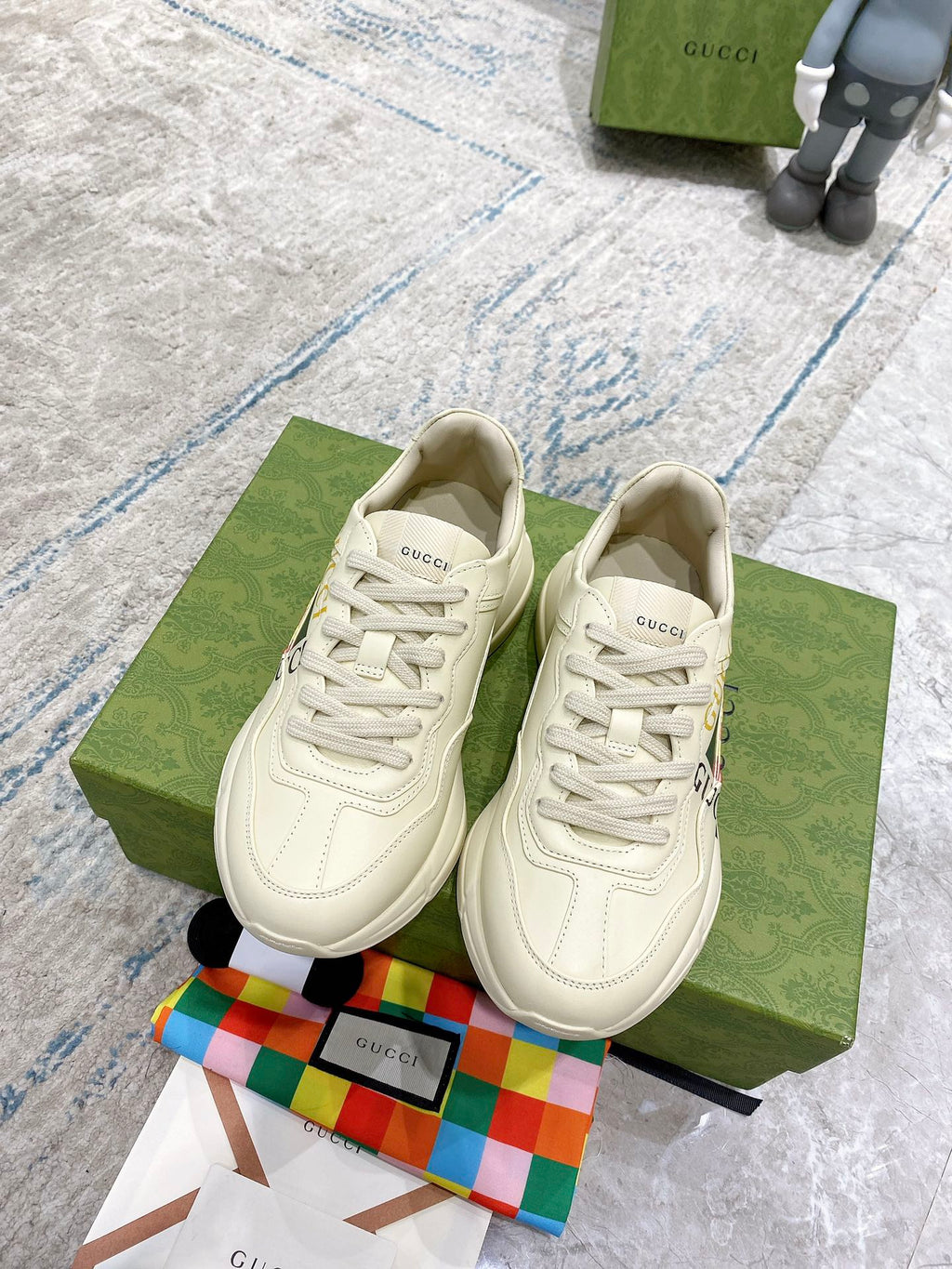 Gucci unisex lace-up sneakers in white with stitched overlays and GG logo accents.