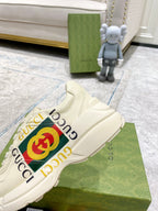 Gucci unisex white sneakers with large GG emblem stripe and lace-up vamp.