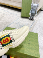 Gucci unisex white sneakers showing GG logo stripe and stitched lace panel.
