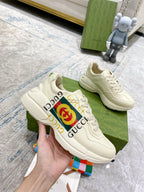 Gucci unisex white low-top sneakers with GG logo stripe and lace-up front.