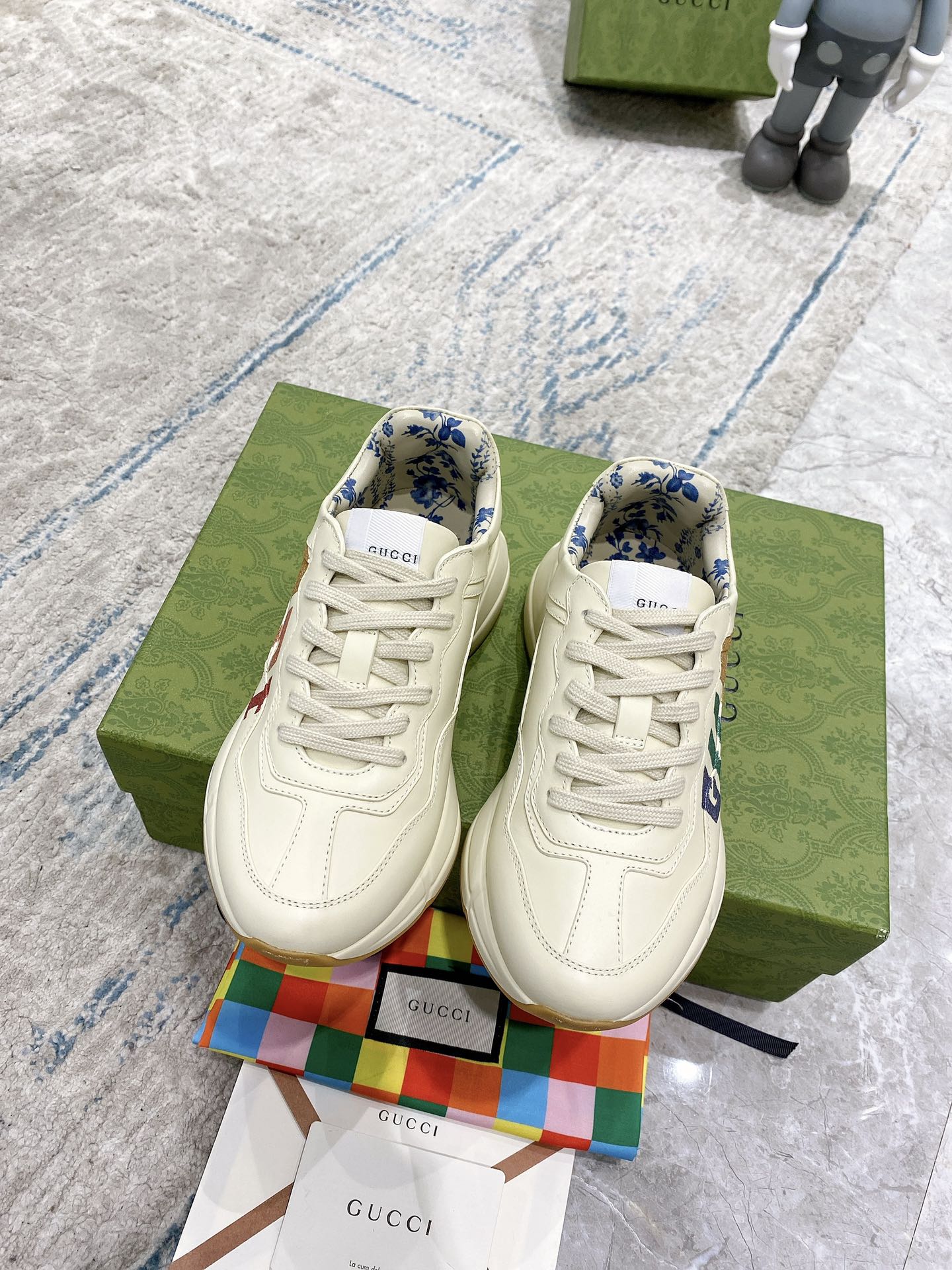 Gucci unisex sneakers pair, cream lace-up fronts with blue patterned lining