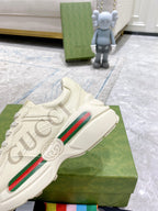 Cream Gucci sneakers close-up, side stripe detail and lace-up upper