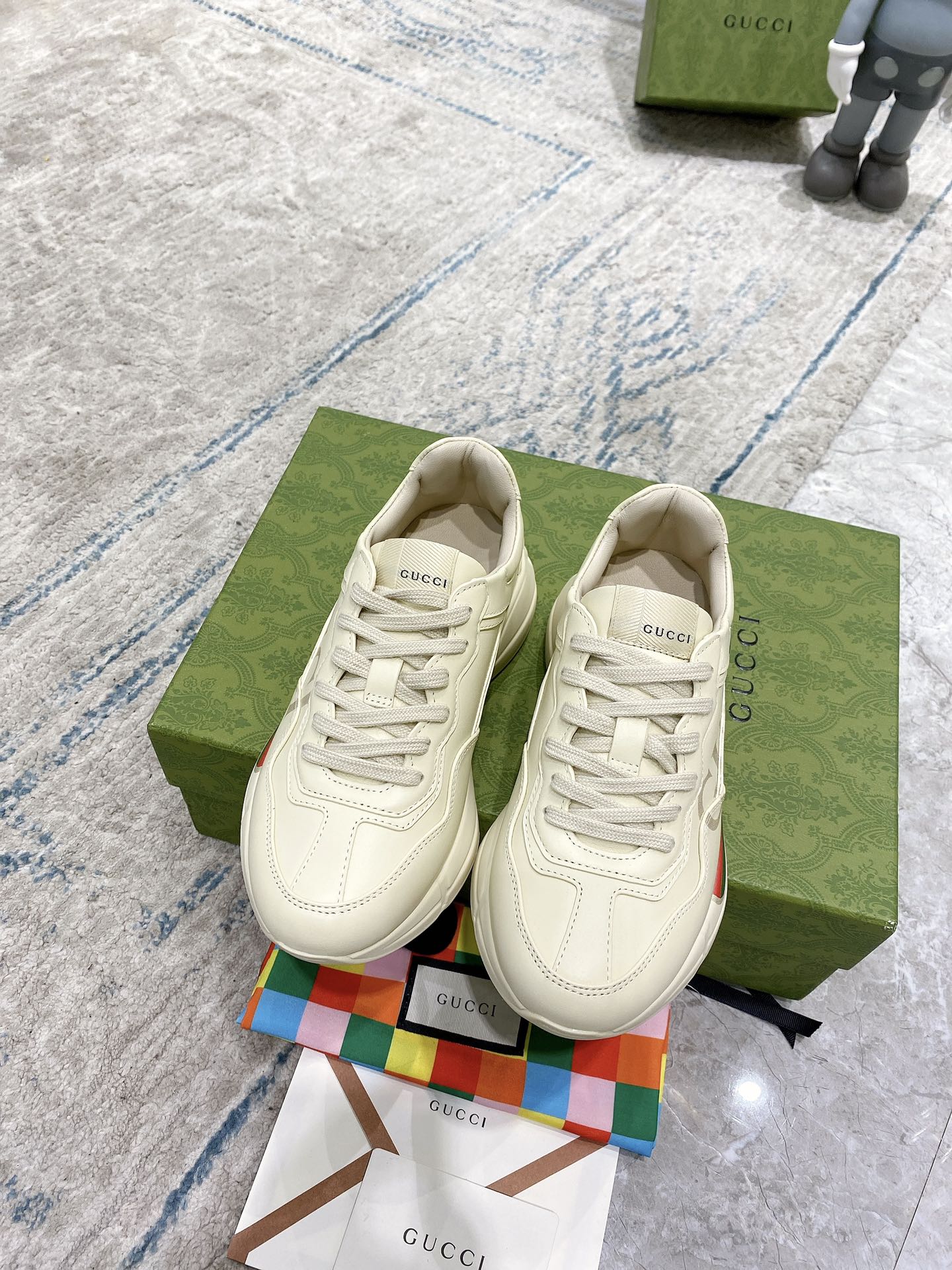 Cream leather lace-up Gucci sneakers, side view with green red web stripe detail