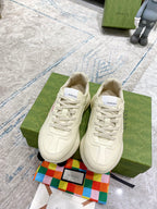 Cream Gucci lace-up sneakers with pink logo print and textured side panels.