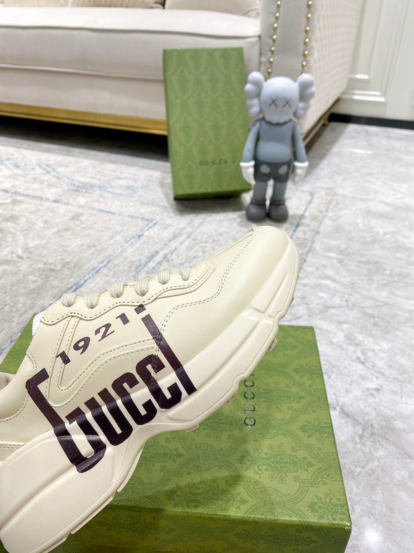 Gucci unisex sneakers in cream, side close-up showing GUCCI 1921 patch and textured sole