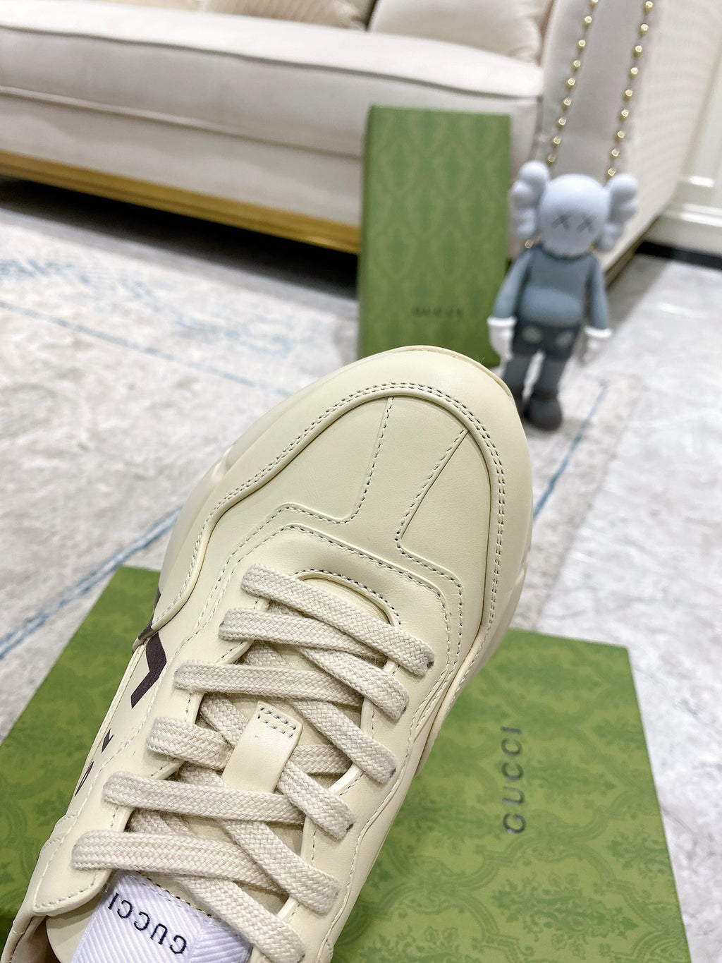 Gucci unisex sneakers in cream, close-up of rounded toe, lace-up eyelets, stitched lines