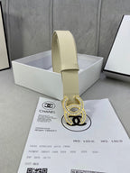 Beige leather belt with Chanel CC rhinestone buckle standing in a white box