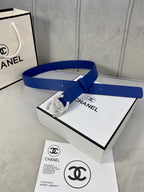 Blue leather belt with rhinestone CC buckle laid across a product box