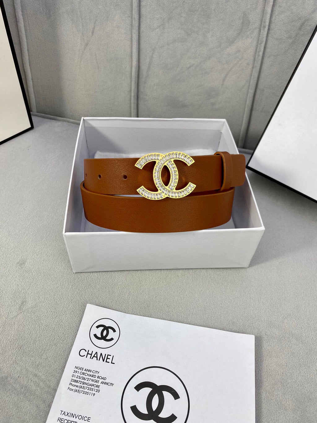 Brown leather Chanel belt with gold-tone rhinestone CC buckle in a white gift box