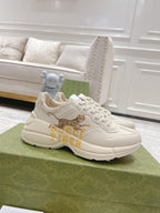 White Gucci unisex sneaker with tiger graphic, lace-up front and chunky sole.