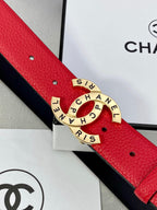 Chanel belt buckle close-up: gold circular CHANEL logo set on red textured leather strap.