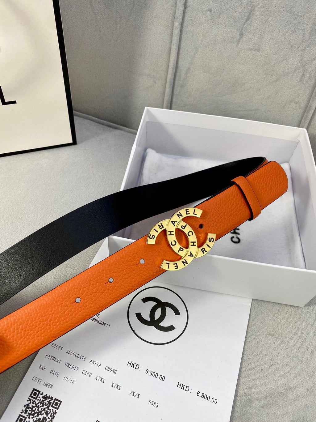 Orange Chanel belt with black lining and round logo buckle in gift box