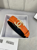 Orange leather belt with black underside and Chanel round logo buckle