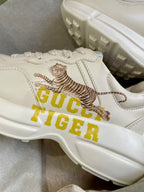 Gucci unisex sneakers close-up, cream leather with tiger print and GUCCI TIGER branding