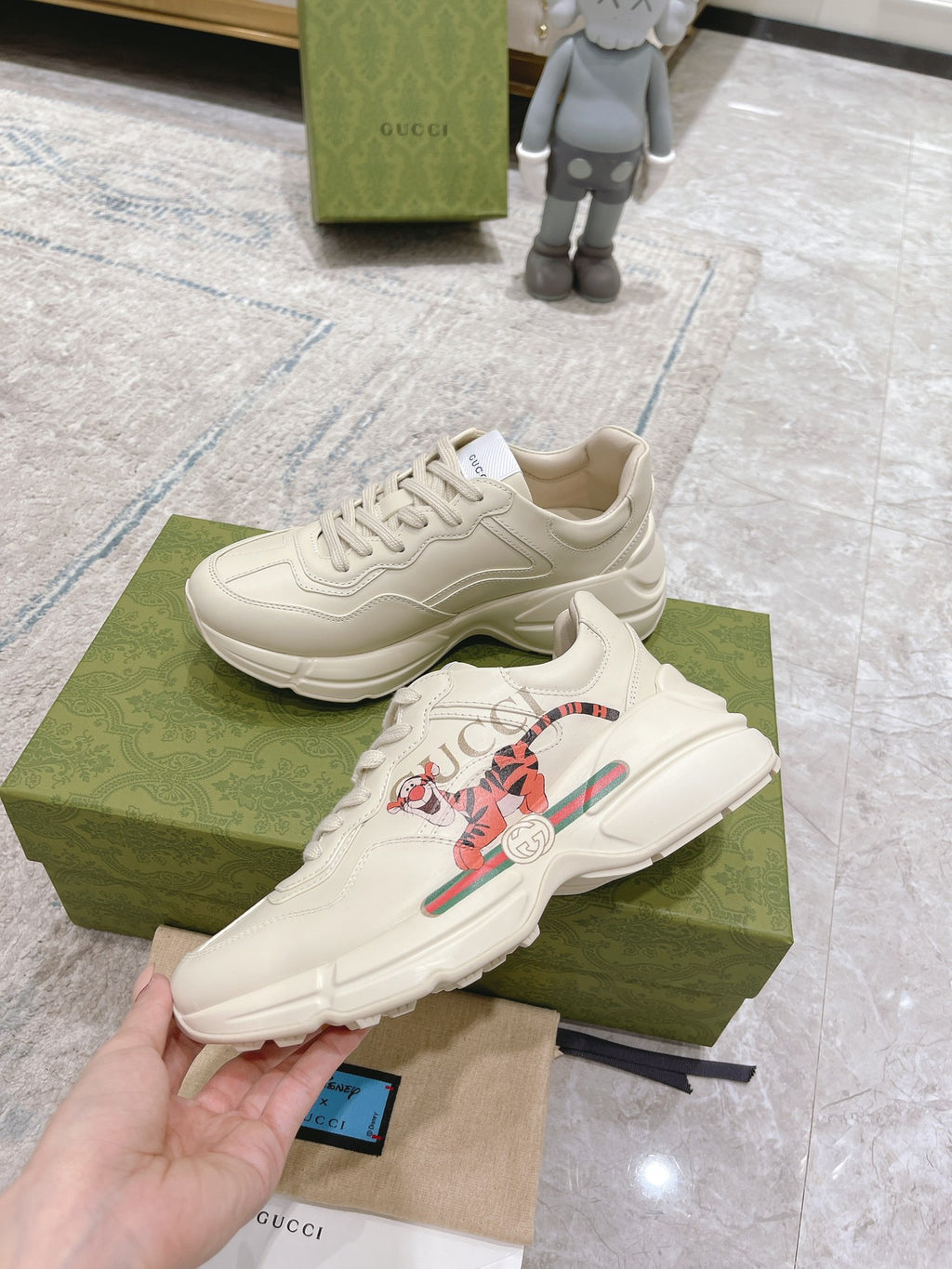 Gucci unisex white luxury sneakers with colorful emblem, shown in angled pair view