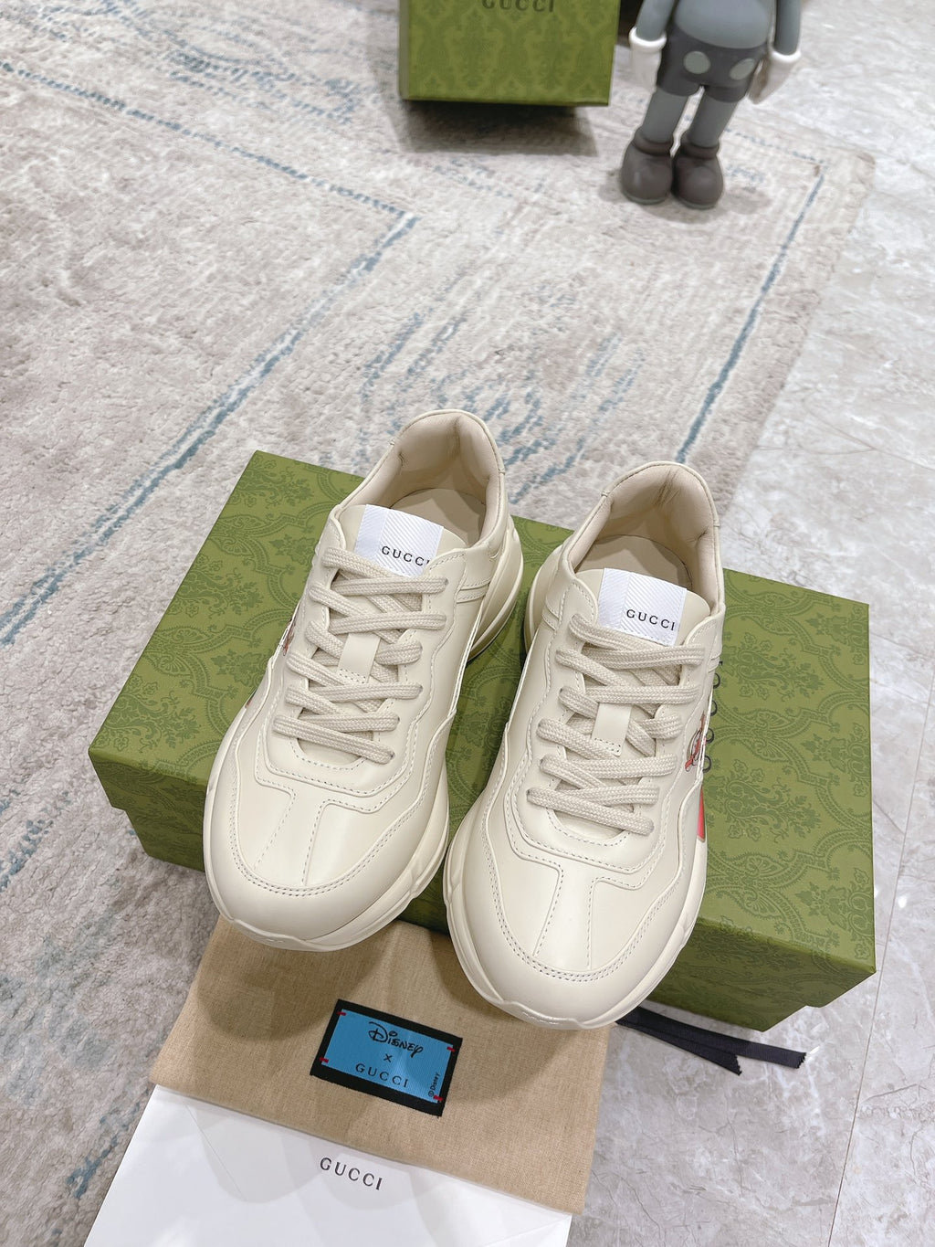 Gucci unisex white luxury sneakers, front view, lace-up with logo stripe detail