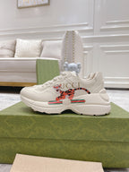 Gucci unisex white luxury sneakers, side view, colorful emblem and web stripe