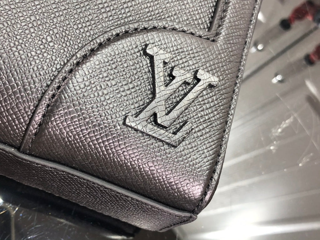 Men's Louis Vuitton tote bag close-up of embossed logo detail on textured leather