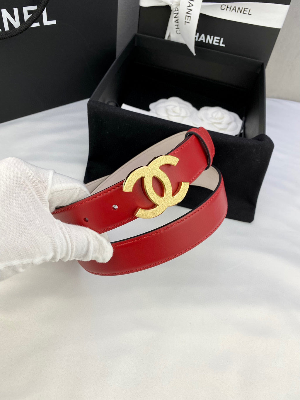 Chanel red leather belt with gold-tone CC buckle on light lining