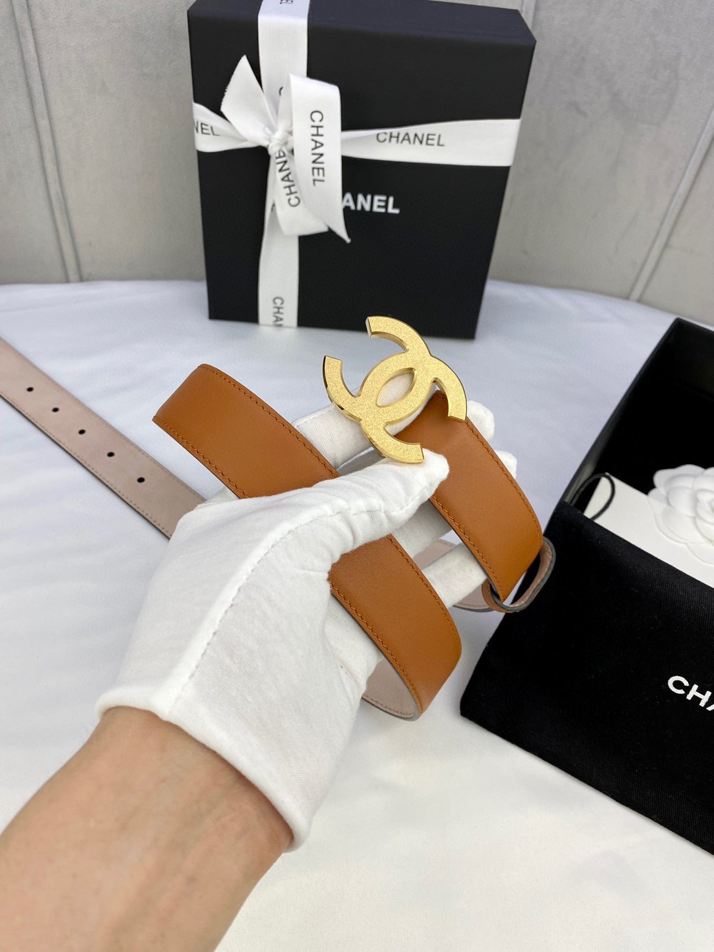 Tan leather belt with gold-tone CC buckle and adjustable holes