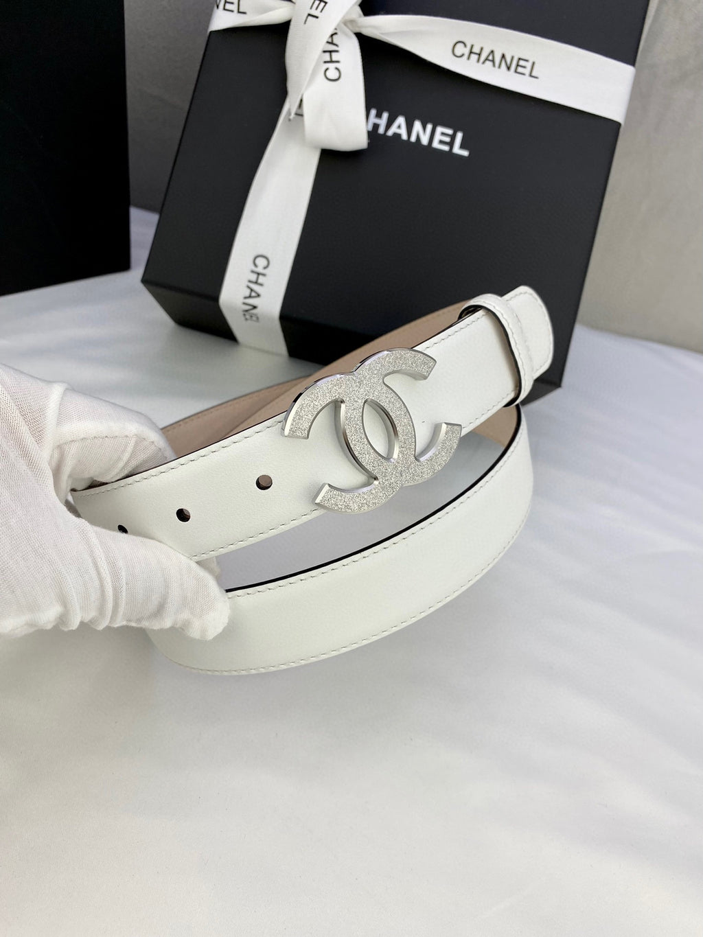 Chanel belt in white leather with large silver CC buckle and metal eyelet holes