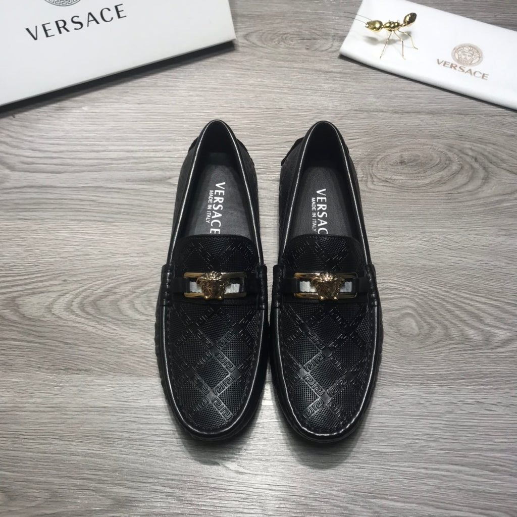 Black Versace loafers facing forward, gold buckle accents on the instep.