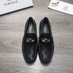 Black Versace loafers facing forward, gold buckle accents on the instep.