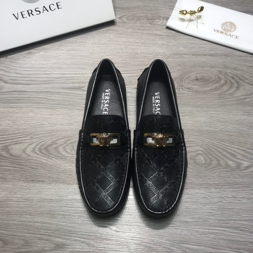 Black Versace loafers facing forward, gold buckle accents on the instep.