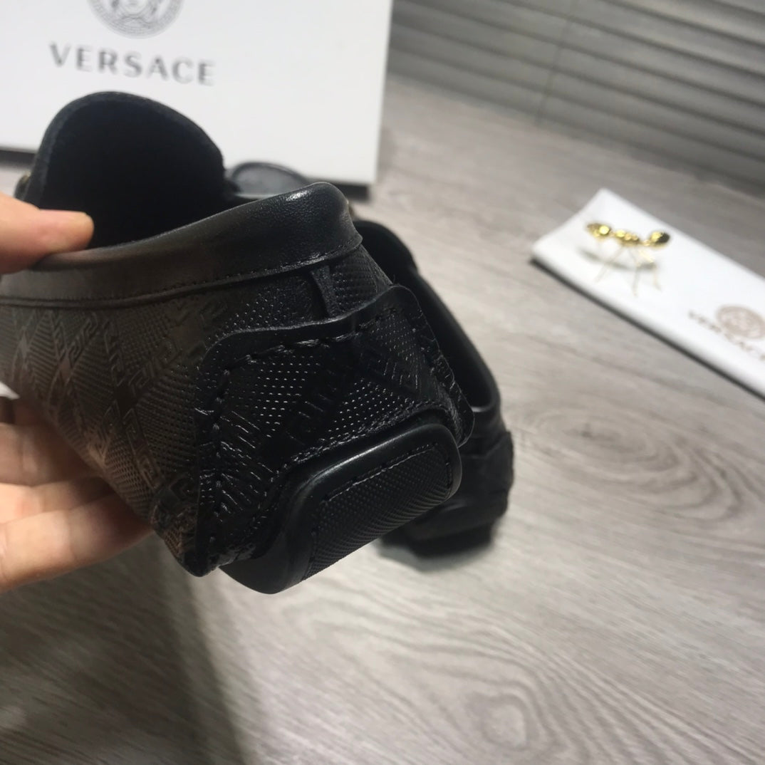 Black Versace loafers side view with textured logo upper and low back collar.