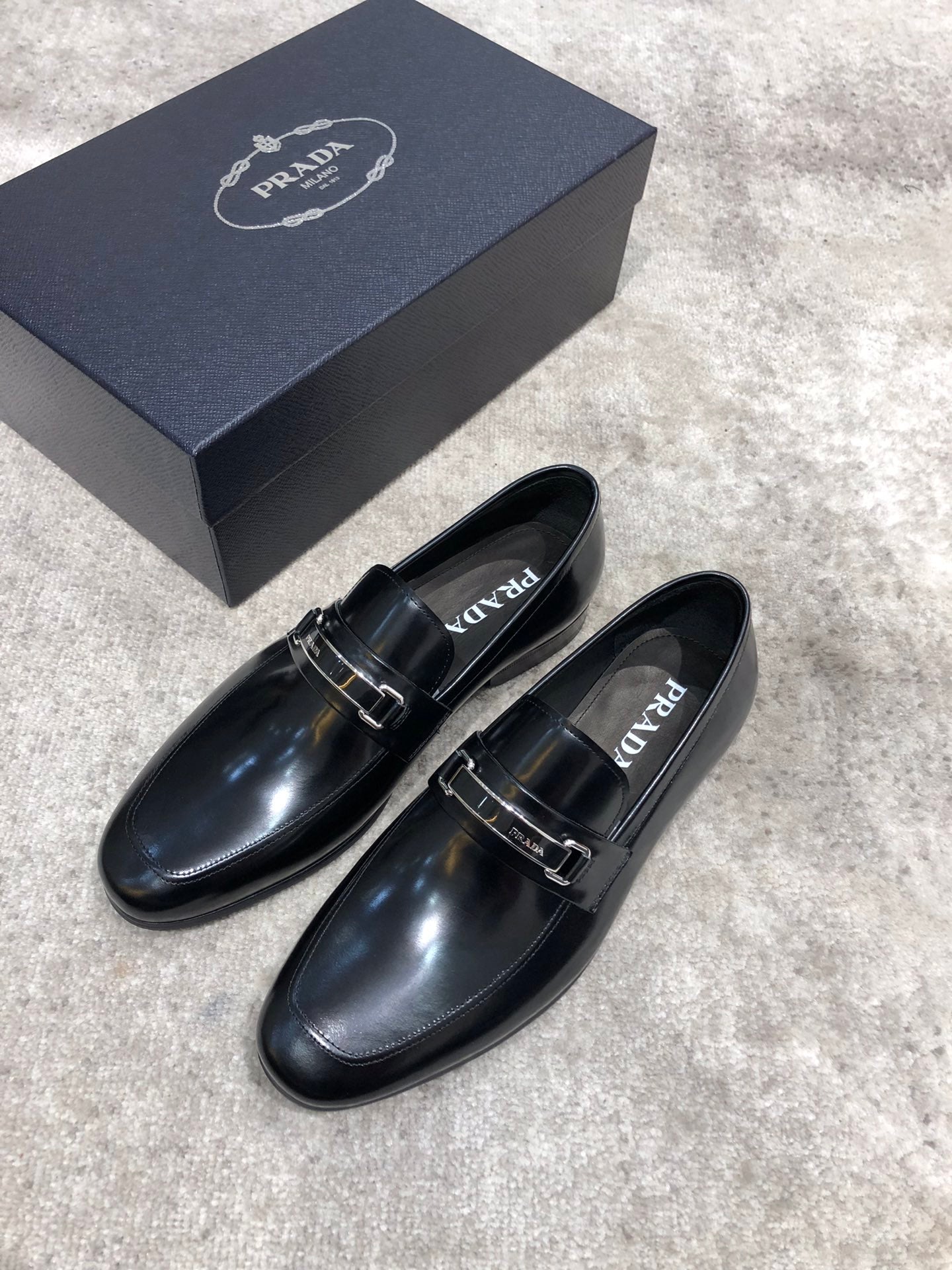 Prada unisex black leather loafers with buckle strap, side view