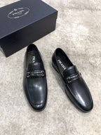 Prada unisex loafers, black leather slip-on with buckle strap, angled view