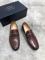 Prada brown leather loafers with front strap and metal buckle, rounded toe