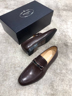 Prada unisex leather loafers, dark brown, front view with metal buckle strap