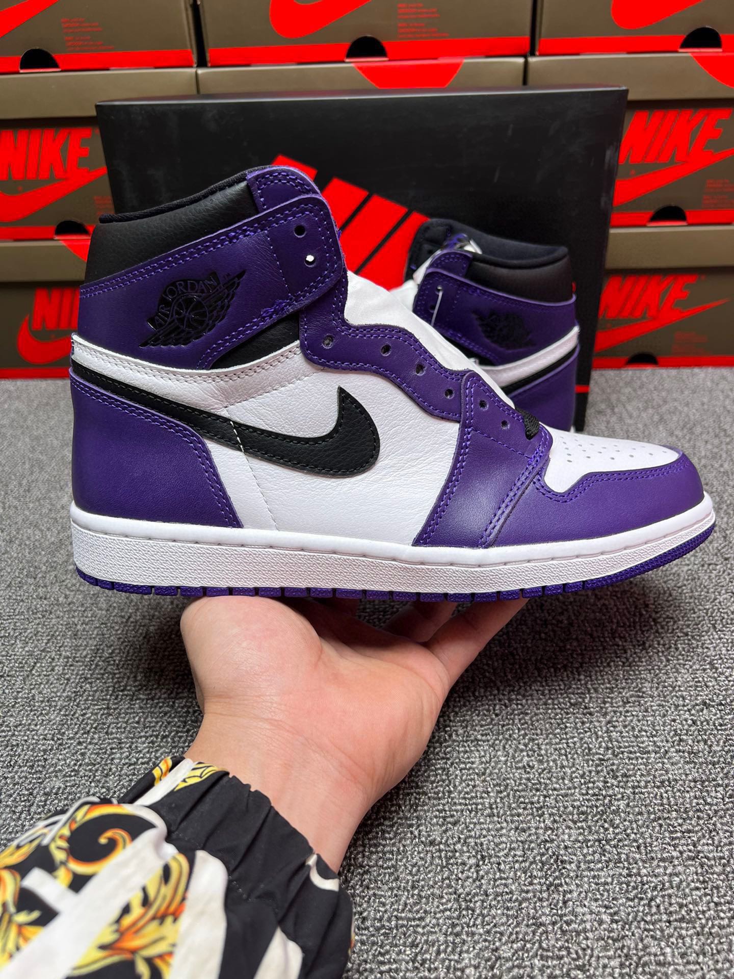 High-top sneakers in white and purple with black Nike swoosh and gray midsole