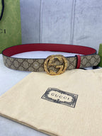 Gucci belt with beige GG canvas, red leather edge, round gold-tone G buckle.