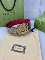 Gucci belt coiled: beige GG canvas with red leather and gold-tone G buckle.