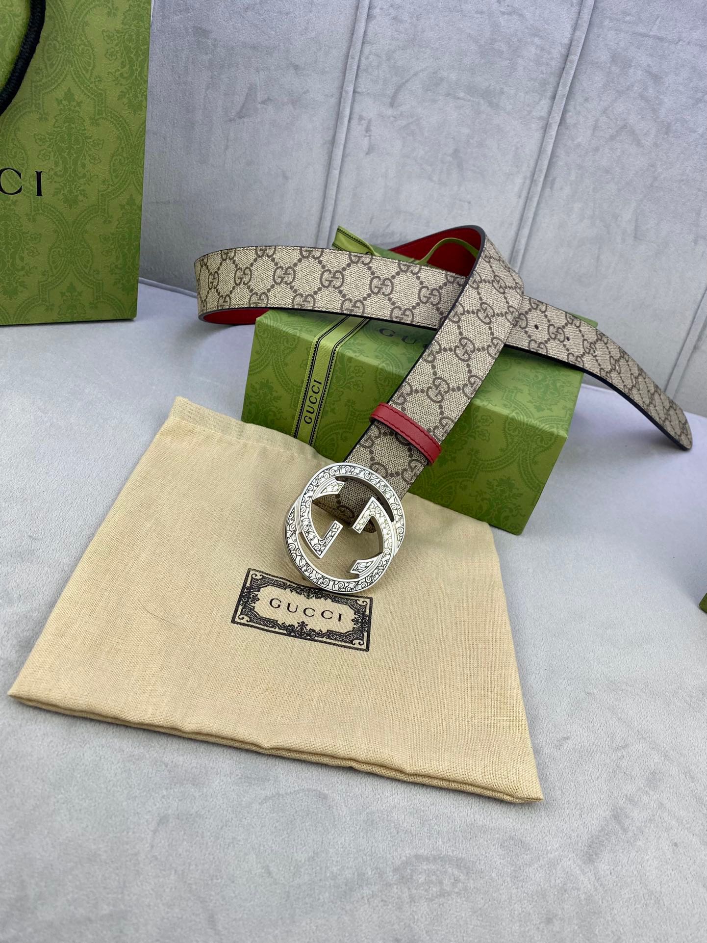 Gucci belt with beige GG canvas strap, red leather, oversized silver-toned G buckle.